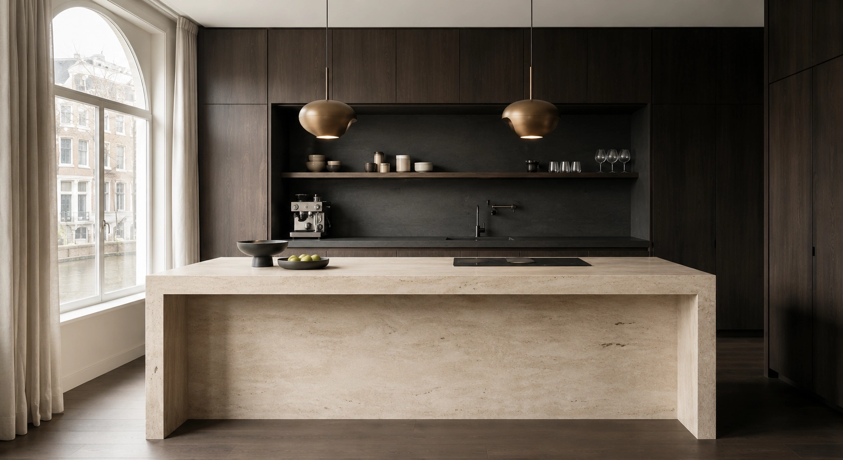 A monolithic travertine kitchen island against dark stained wood cabinetry.